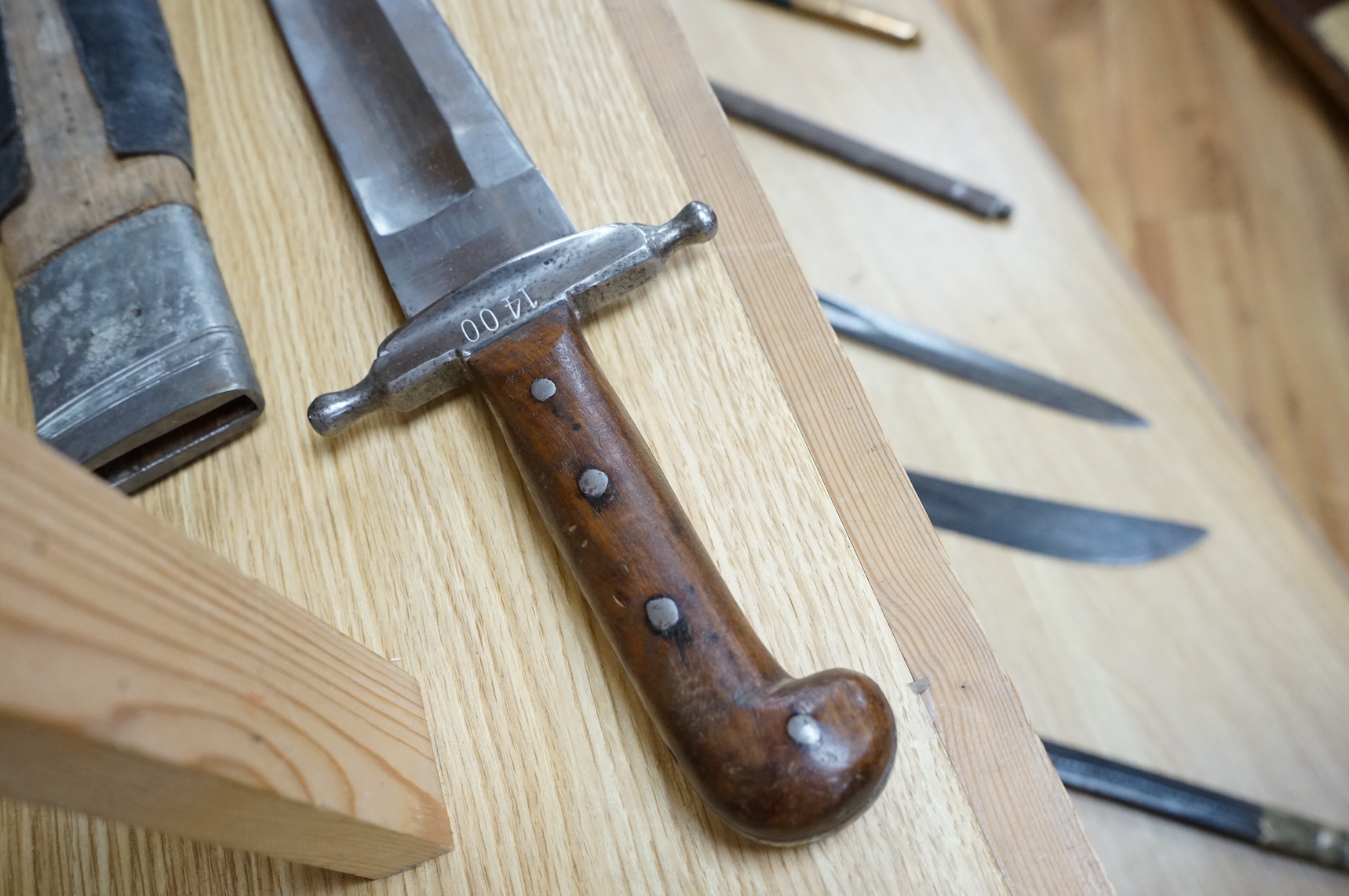 A 19th century Austrian military fascine knife, regulation iron crosspiece, two piece riveted wooden grips, in its wooden scabbard with iron mounts, leather covering loose